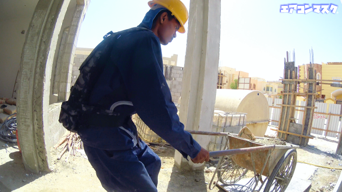 二輪車で砂を運ぶ作業員 マスク