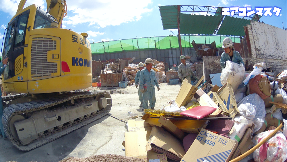 手作業で処理する。暑い 日本の産業廃棄物処理現場